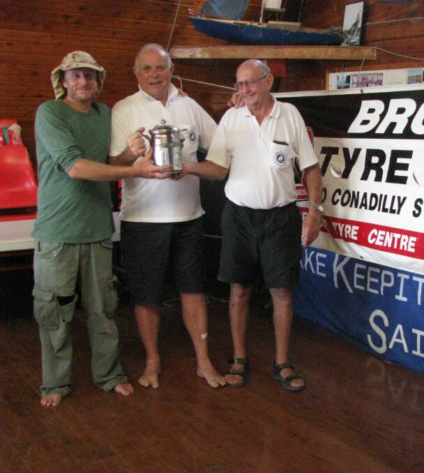 Congratulations: Long-time Lake Keepit Sailing Club member John Rabe presents the Keepit Kup Trophy to crew Grayem White (left) and skipper Stan White (right).