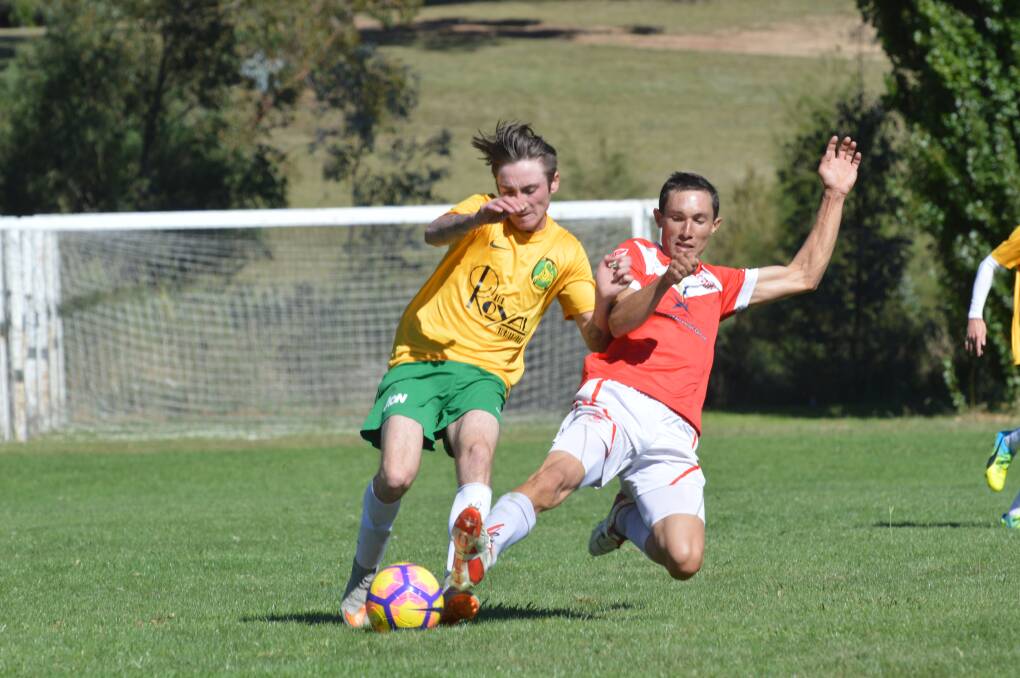 Battle: South Armidale's Cody Watts is tackled by Oxley Vale Attunga rival Eli O'Donnell during Saturday's FFA Cup clash. Photo: Gregor Mactaggart