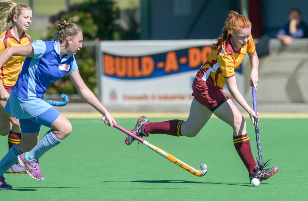 On the run: Olympians' Flo Davidson gives chase to Tudor Wests' Tessa Mitchell during their clash on Sunday. Millie Sherwood is in the background. Photo: Peter Hardin