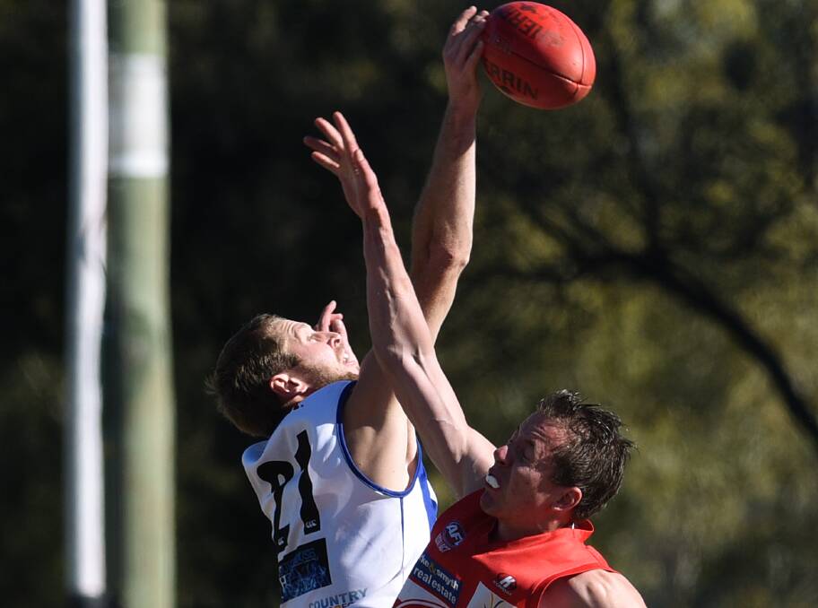 Handball: Roos ruckman Ben Mitchell wins out against the Swans' Andrew Finlay in Saturday's big win, which they set up with a big first half. Photo Gareth Gardner.