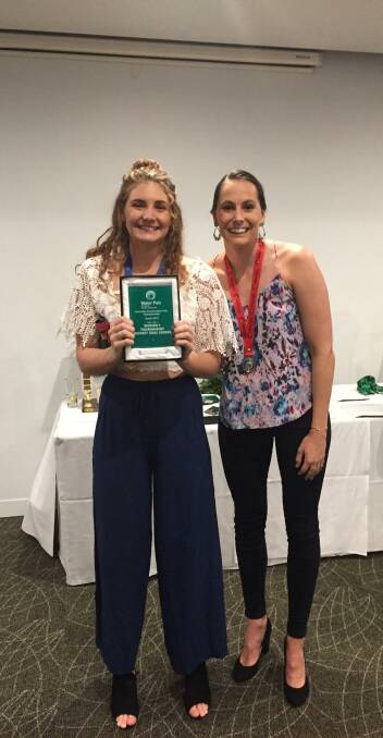 Laura Robinson (left) with her top goalscorer award and Olympian Kelsey Wakefield, who played for Queensland.