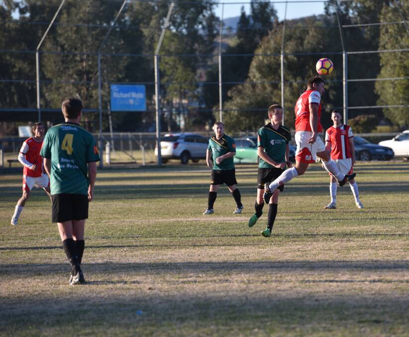 Airborne: Tim Smith leaps high to head this ball forward for Oxley Vale Attunga against Joeys on Sunday.