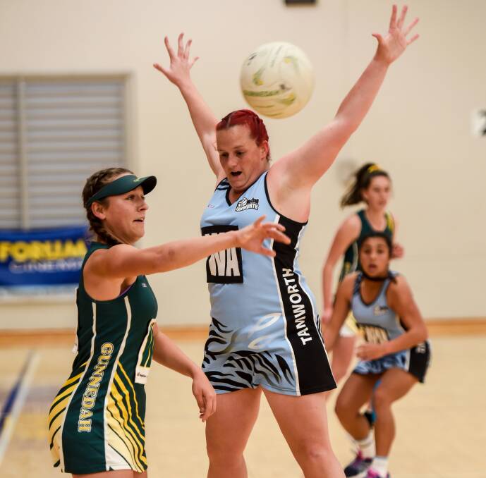 Arms up: Tamworth's Sarah Miller defends this pass from Gunnedah's Madeline Buhagiar during their semi-final on Sunday. Photo: Peter Hardin 210816PHA83