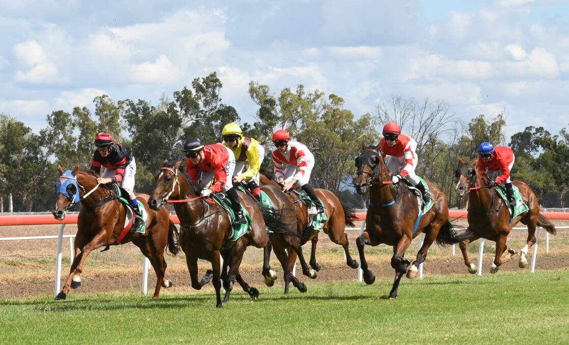 Pretty Pine (white with red v) settles in behind the leaders first time past the winning post.