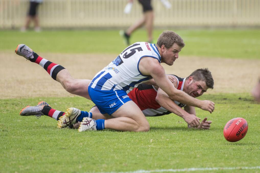 Determination: Tamworth Kangaroos centre half-forward Matt Hodge competes with this Inverell player for possession during their match-up last week. Photo: Peter Hardin 130517PHC226