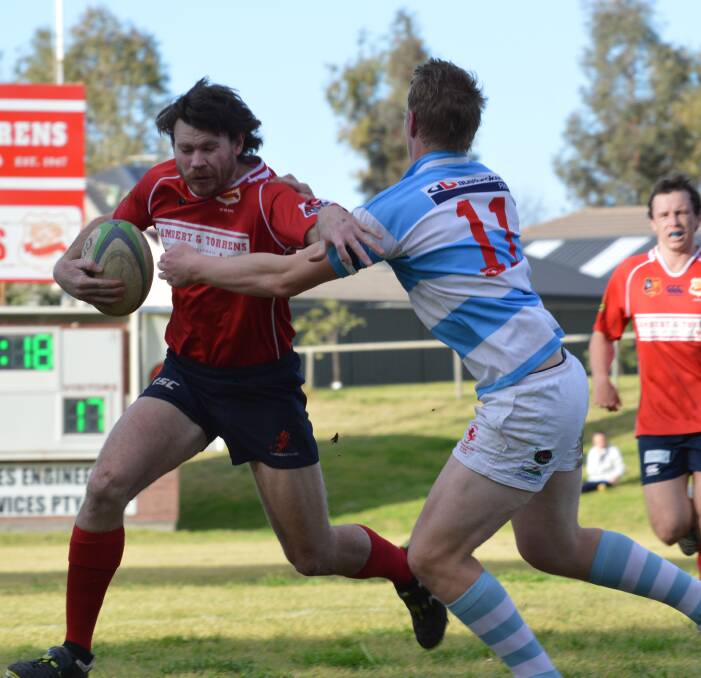 On the attack: Gunnedah's Tom Adams looks to brush off the attentions of Quirindi's Jake Smith after coming on in the second half of Saturday's final round clash. Adams earlier scored a double in second grades win.