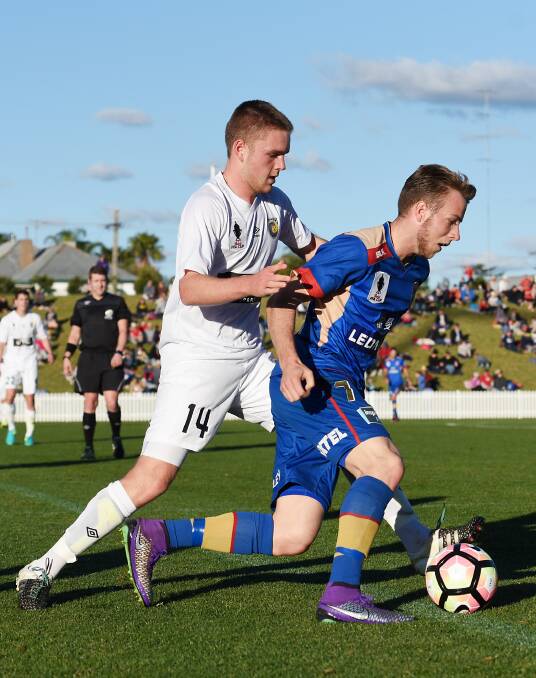 Defence: Central Coast's Adam Berry attempts a steal on Newcastle's Andrew Hoole during Saturday's A-League trial. Photo: Gareth Gardner 130816GGE37