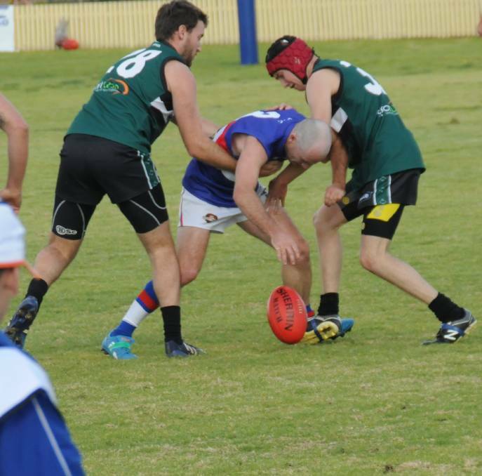 Swamped: Gunnedah Bulldogs David Vidovic is sandwiched by two New England Nomads players in Tamworth AFL action at Wolseley Oval on Saturday.