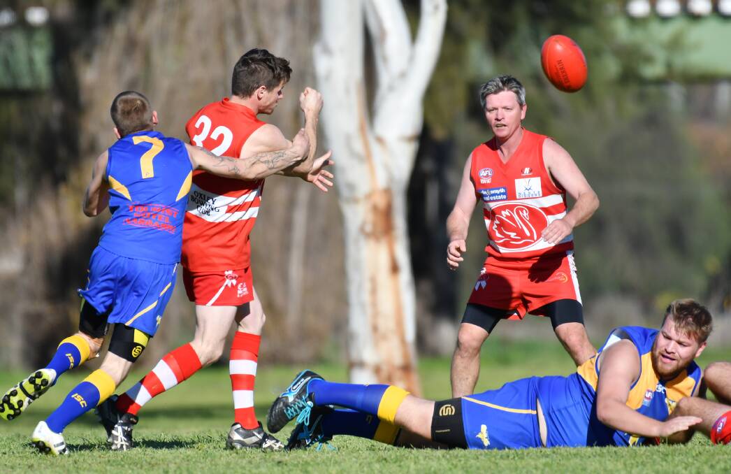 Clear: Will Priest handballs out of danger for Tamworth Swans as Narrabri's Graeme Dixon (7) arrives to tackle. Damien Wendt and Eagle Nicolas Finger (ground) look on.