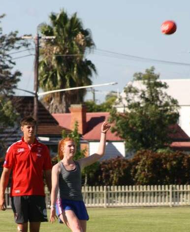 On her way: Elle Ford training earlier this year with Sydney Swans superstar Callum Sinclair. She has been named in youth girls AFL State Cup team. 