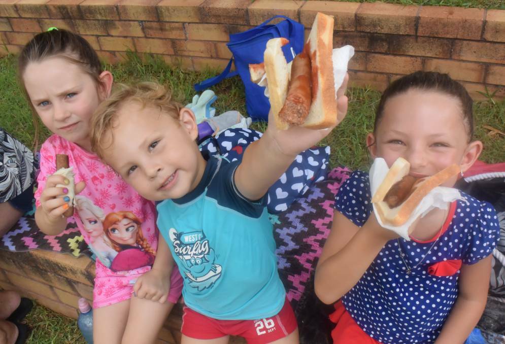 LITTLE AUSSIES: Manilla kids Rhylea Vipen, 3, Owen Gardner, 3, and Maddy Gardner, 6, tuck into some snags at the local pool on Australia Day. Photo: Ella Smith