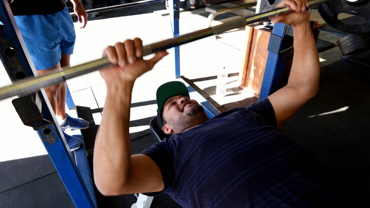 SWEAT IT OUT: Barega Knox tried his hand at some bench presses and said finding motivation and time were key hurdles for men when it came to fitness.  Photo: Gareth Gardner 140617GGC04