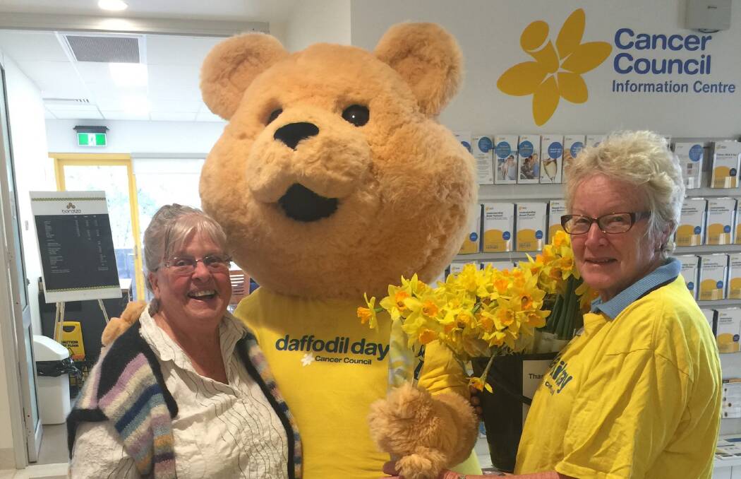 KIND DONATION: From left: Patricia Wallace, Dougal Bear, and North West Cancer Centre volunteer Marilyn Seiler with flowers for local cancer patients. Photo: Supllied 