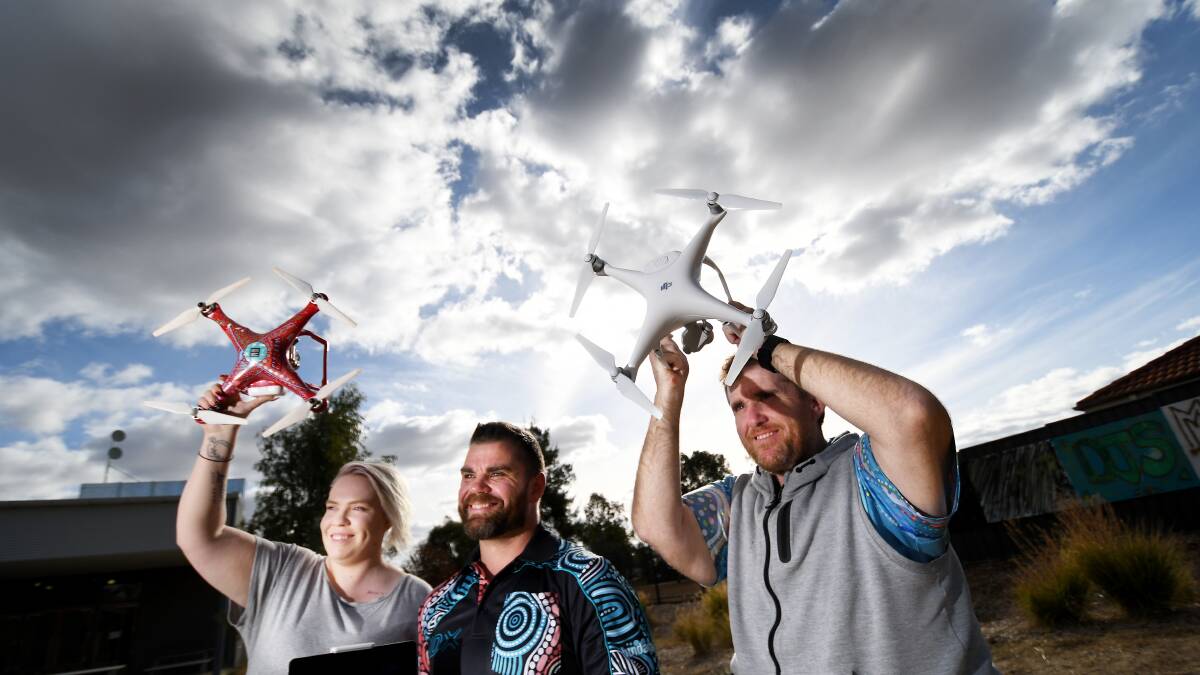 SKY HIGH: From left: Tess Reading, Indigenous Digital Excellence program manager Grant Cameron and Danny Dalton with drones which could open Coledale to the nation. Photo: Gareth Gardner 200618GGD002