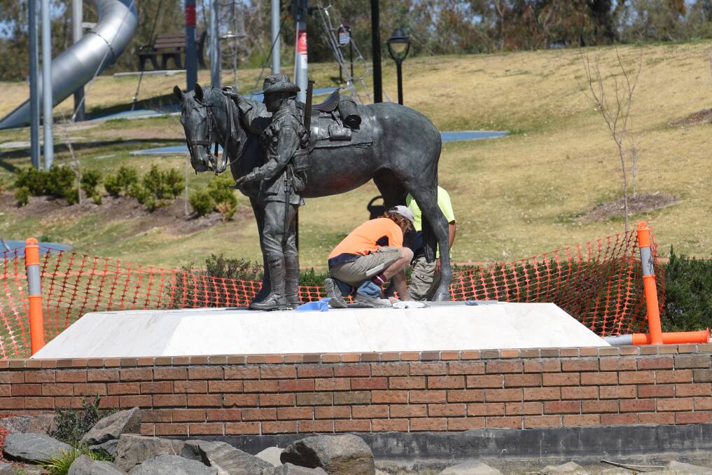 DAMAGE DONE: Workers replace damaged tiles on the Bronze Whaler statue in Bicentennial Park after Year 12 treasure hunt goes pear-shaped. Photo: Gareth Gardner