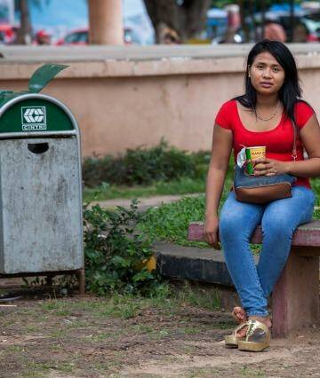 A sex worker sits on one of the benches of Wat Phnom Park, situated in central Phnom Penh.  Photo: Ken McKay