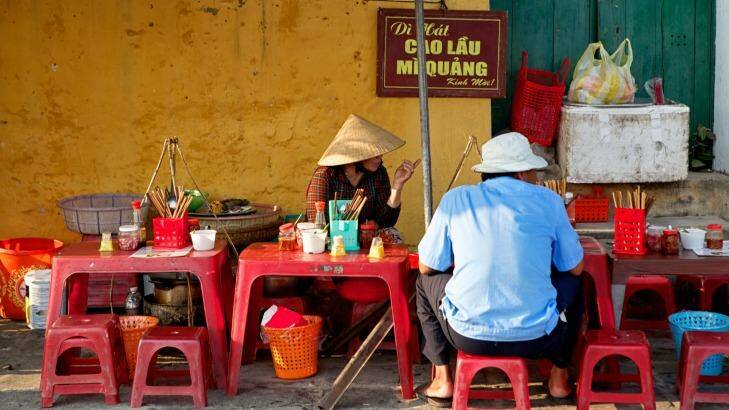A woman selling Cau Lau, a local noodle specialty on a street sidewalk in Hoi An, Vietnam. Photo: Jeremy Villasis