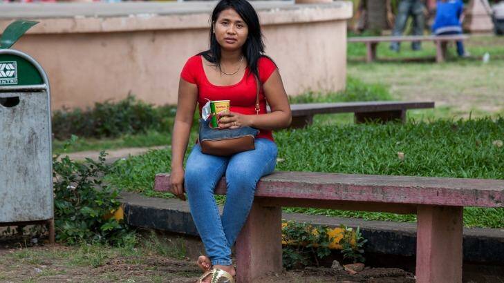 A sex worker sits on one of the benches of Wat Phnom Park, situated in central Phnom Penh.  Photo: Ken McKay