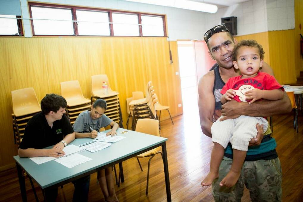 Citizen's right: Stephen Edwards with his son, Coen, while partner Melinda Jarrett fills out the forms for Coen's first birth certificate.  Photo: Supplied