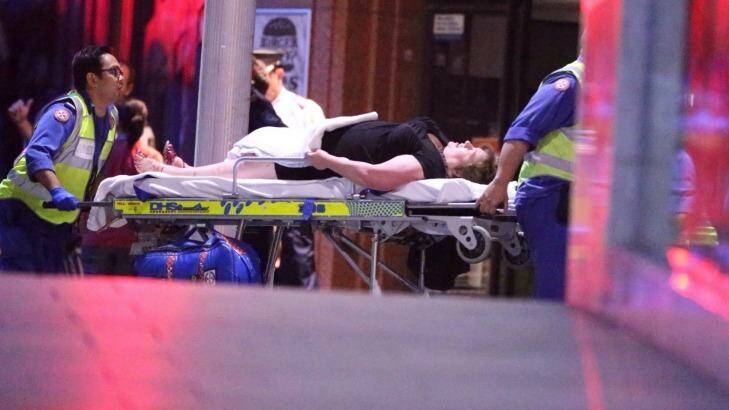 Free: a hostage is taken away by paramedics. Photo: Andrew Meares