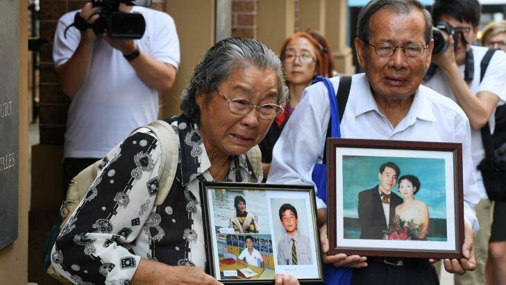 Min Lin's parents, Feng Qing Zhu (left) and Yang Fei Lin, outside the Supreme Court with photos of their murdered family members on Friday. Photo: Peter Rae