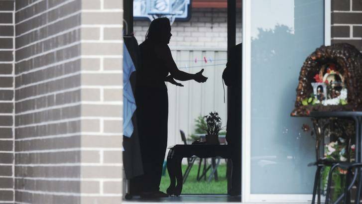 A woman argues with police as her home is raided in Eustace Avenue, Fairfield Heights. Photo: Nick Moir
