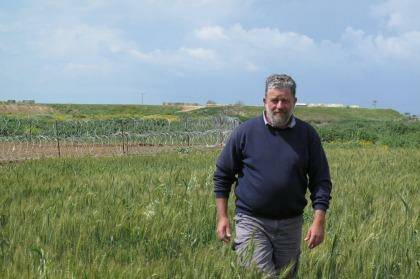 Pablo Leffler stands in the farmlands of Kibbutz Ein HaShlosha. The structures and razor wire behind him surround of the Hamas tunnels discovered by the Israel Defence Forces last year. Photo: Ruth Pollard