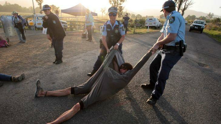 Police seize a protester. There is a large police and private security presence.  Photo: Dean Sewell