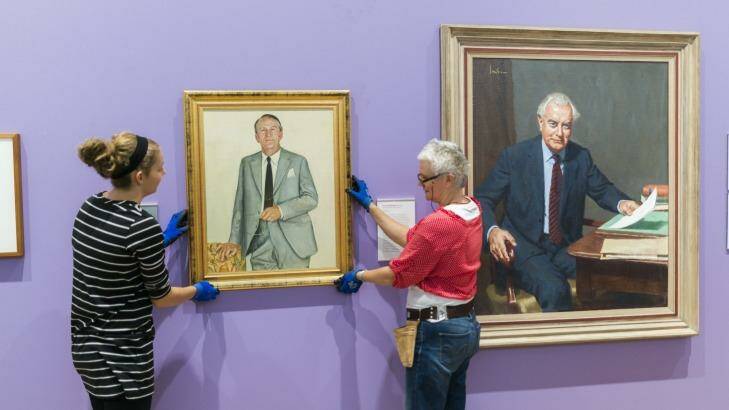 National Portrait Gallery staff hang two portraits former PM Malcolm Fraser next to portraits of Gough Whitlam after news of Fraser's passing overnight.  Photo: Rohan Thomson