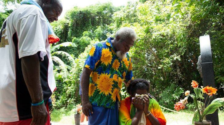 Eddie Mabo's daughter, Celuia Mabo, is comforted by William Bero, centre, and Evan Noah, at the grave of her father, on Mer Island in the Torres Strait. Photo: Janie Barrett