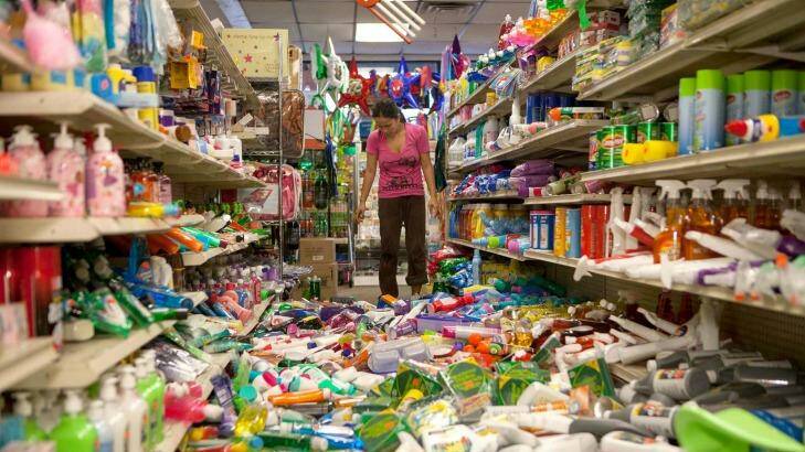 Nina Quidit cleans up the Dollar Plus and Party Supplies Store in American Canyon, California after Sunday's earthquake. Photo: Alex Washburn