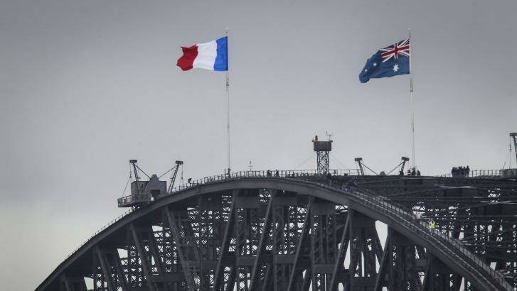 The French flag is raised alongside the Australian flag on the Sydney Harbour Bridge on Sunday. Photo: David Porter