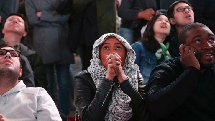 People watching election results in Times Square, including Adama Fadiga. Photo: Seth Wenig/AP