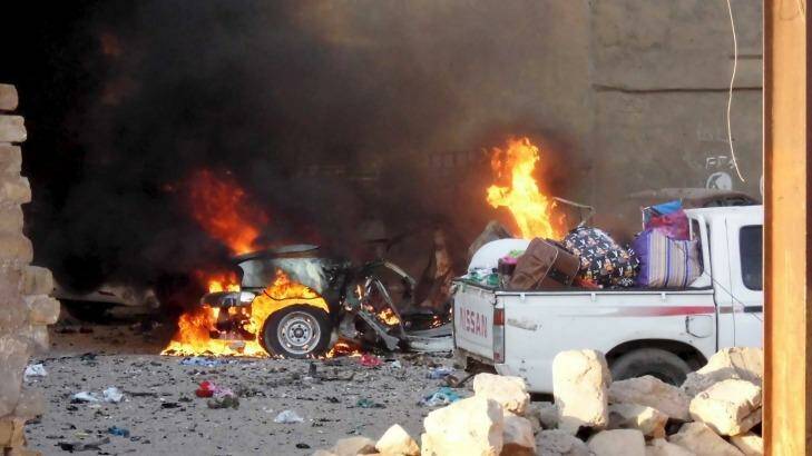 A car is engulfed by flames during clashes in the city of Ramadi on Saturday. Photo: STRINGER/IRAQ