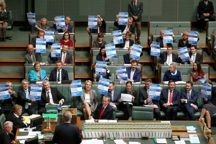 Labor MPs hold up signs on school funding to Prime Minister Malcolm Turnbull during Question Time at Parliament House in Canberra on Tuesday 2 February 2016. Photo: Alex Ellinghausen