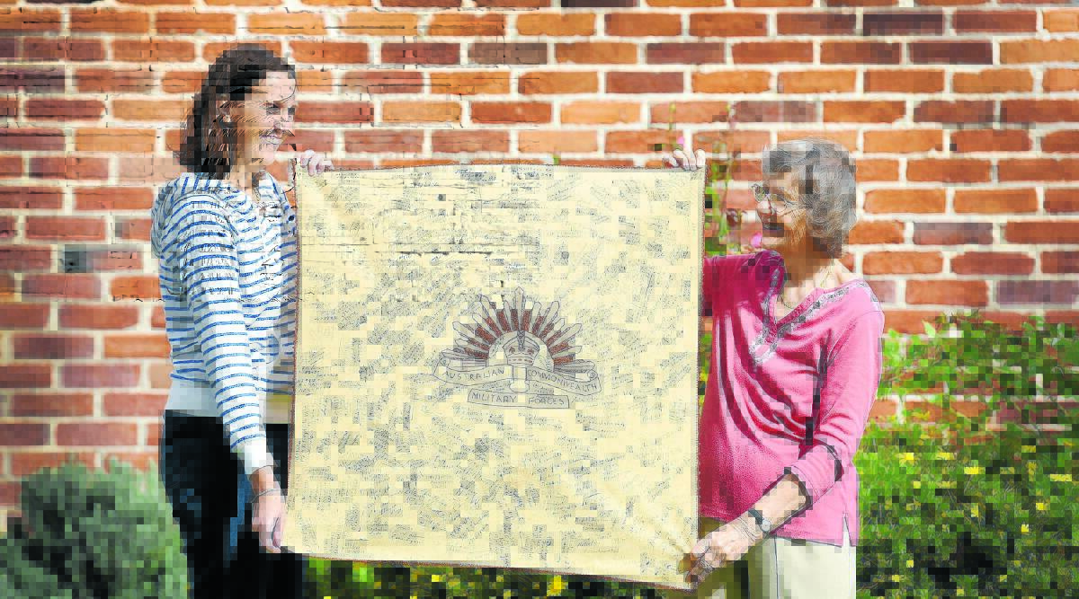 WAR WORDS: Melinda Gill and Jan Morris with the World War II signed banner cloth discovered in a bottom drawer at the local historical society office in Tamworth. Photo: Gareth Gardner 100516GGA01