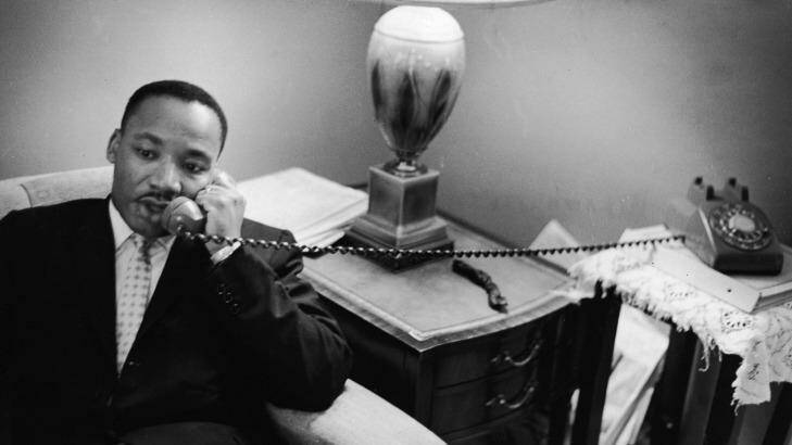 American civil rights leader Dr. Martin Luther King, Jr. (1929 - 1968) sits on a couch and speaks on the telephone after encountering a white mob protesting against the Freedom Riders in Montgomery, Alabama, May 26, 1961. Photo: Express Newspapers/Getty Images