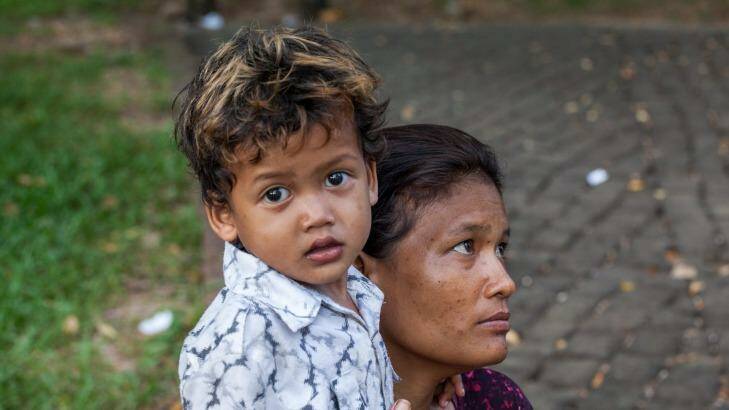 Srey Kuoch, a sex worker and drug user, hugs her young son, Chan Vutha, in Wat Phnom Park, opposite the residence of the Australian ambassador.  Photo: Ken McKay