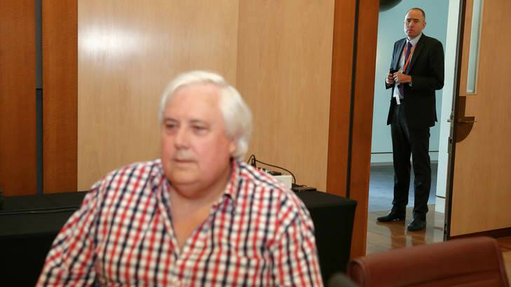 Clive Palmer adviser Ben Oquist stands behind the PUP leader before a press conference. Photo: Alex Ellinghausen