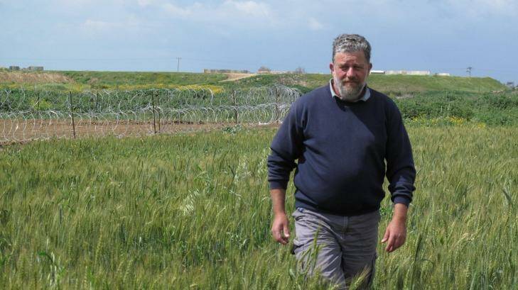 Pablo Leffler stands in the farmlands of Kibbutz Ein HaShlosha. The structures and razor wire behind him surround of the Hamas tunnels discovered by the Israel Defence Forces last year. Photo: Ruth Pollard