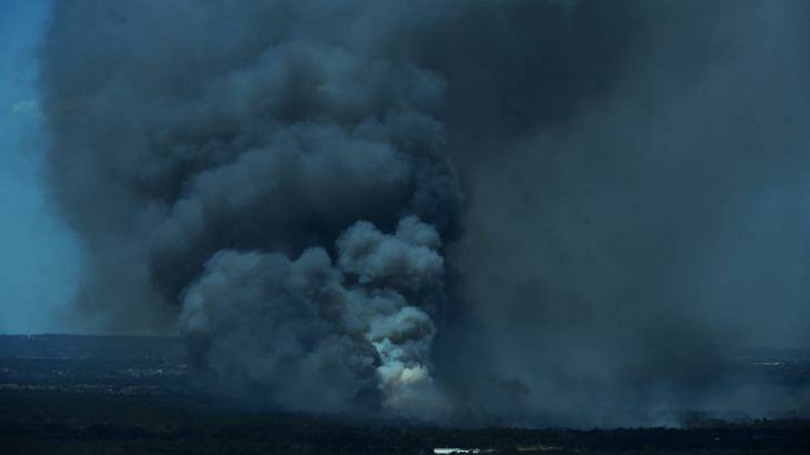 Thick black smoke erupts from the out of control bushfire. Photo: Wolter Peeters