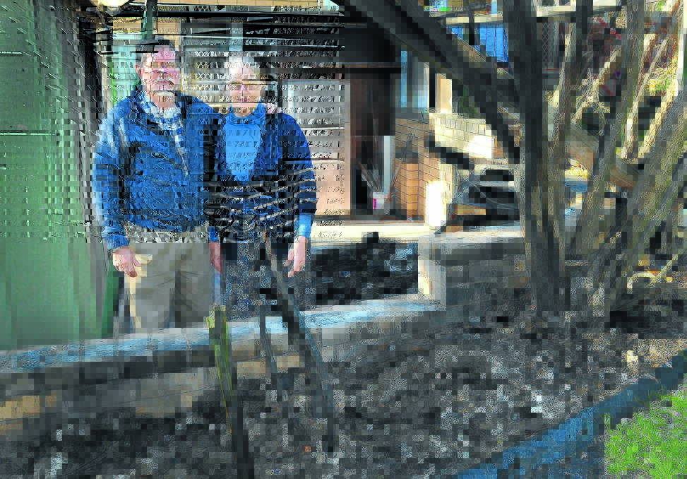 THANKS AND BE WARNED: Stuart and Marion Andrews, among the ashes of their shed and carport, have thanked firefighters and neighbours and warned others to avoid their mistakes. Photo: Geoff O Neill 280814GOB02