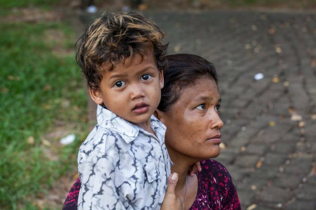 Srey Kuoch, a sex worker and drug user, hugs her young son, Chan Vutha, in Wat Phnom Park, opposite the residence of the Australian ambassador.  Photo: Ken McKay