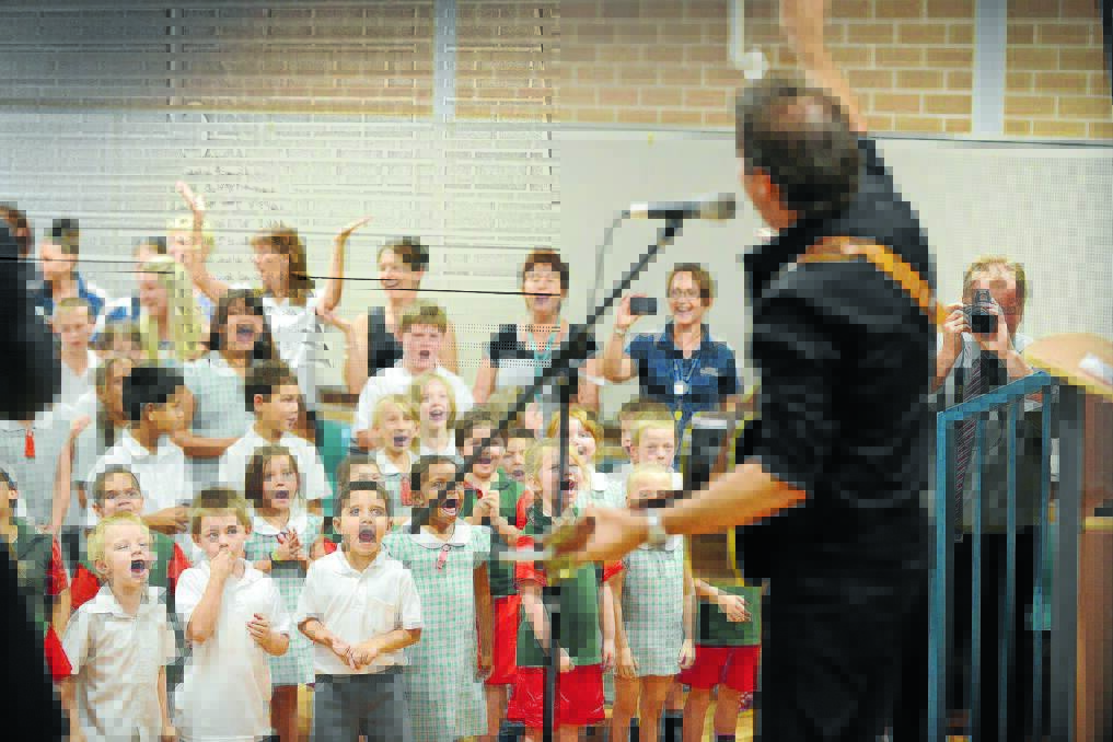 ON SONG: Troy Cassar-Daley gets the students involved in a rendition of a Wiggles song at Hillvue Public School as he launched Tune In To Recycling. Photo: Barry Smith 021214BSB17