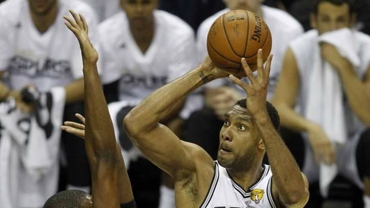 It's on: Spurs big man Tim Duncan scores over Chris Bosh in the opening quarter. Photo: Reuters