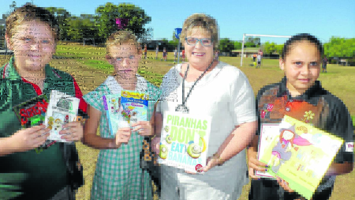 Cameron Lee, Eleisha McKay, author Lyn Grace and Savannah Nean with some of the books Hillvue students can now take home.