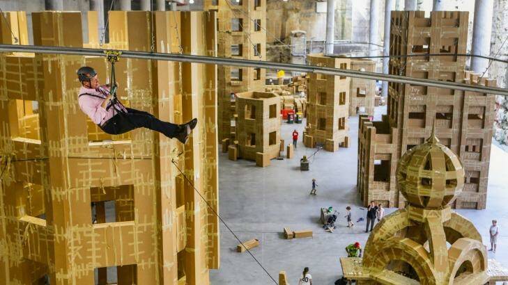 Deputy Premier and Arts Minister Troy Grant rides the flying fox above the cardboard Ephemeral City built during the 2016 Sydney Festival.  Photo: Dallas Kilponen