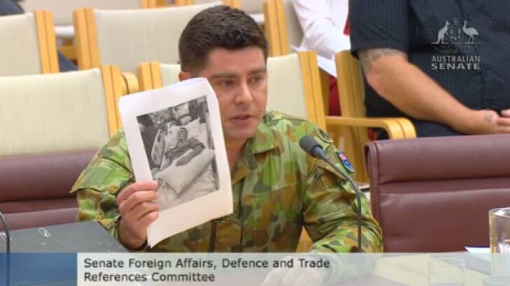 Former SAS trooper Evan Donaldson shows a Senate inquiry a photograph of his brother Andrew in a coma. Photo: Australian Senate