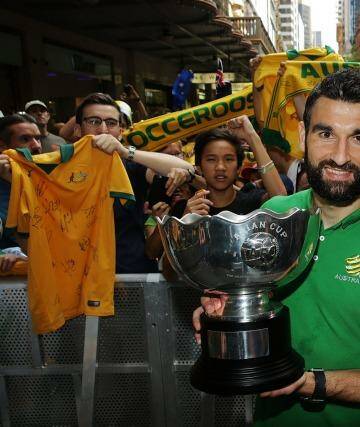 Proud achievement: Socceroos captain Mile Jedinak poses with the Asian Cup during celebrations at Westfield Sydney on Sunday. Photo: Mark Metcalfe