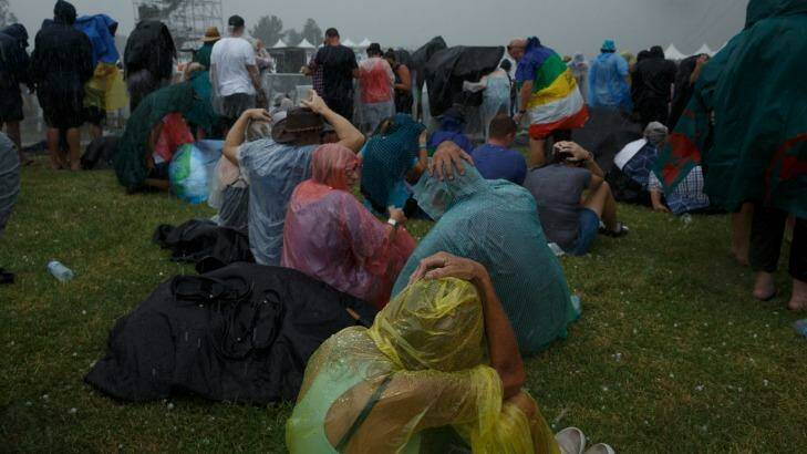Crowds attempt to shelter from a barrage of hailstones at a Bruce Springsteen concert at Hope Estate, Pokolbin. Photo: Max Mason-Hubers